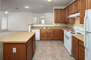 A kitchen with wooden cabinets and a white refrigerator.